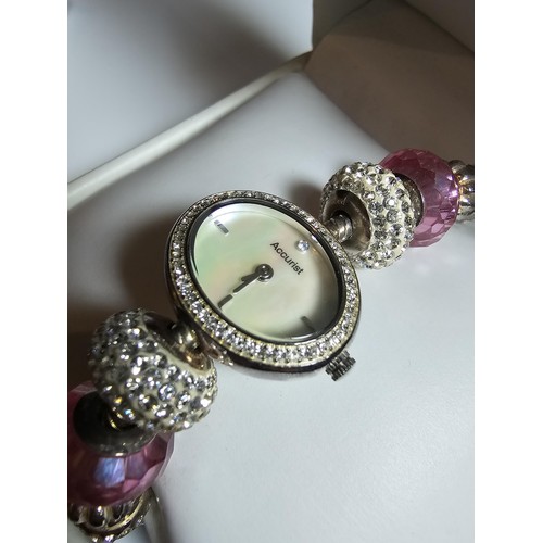 190 - a Charmed by Accurist ladies wrist watch having a Mother of Pearl dial and a jewelled charm bracelet... 