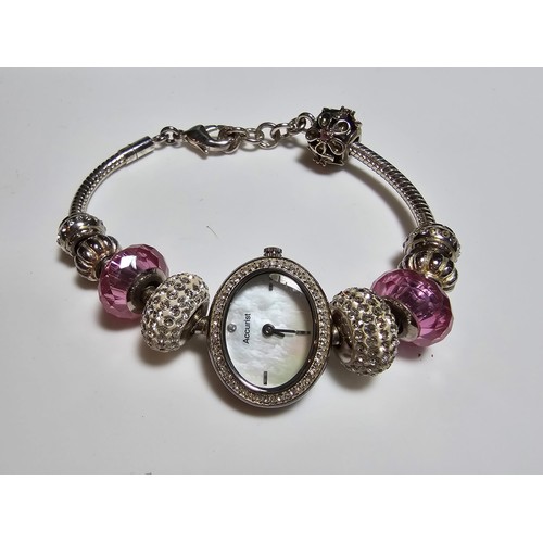 190 - a Charmed by Accurist ladies wrist watch having a Mother of Pearl dial and a jewelled charm bracelet... 