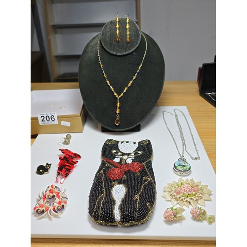 206 - A box containing a quantity of costume jewellery items including a good quality black white sequined... 