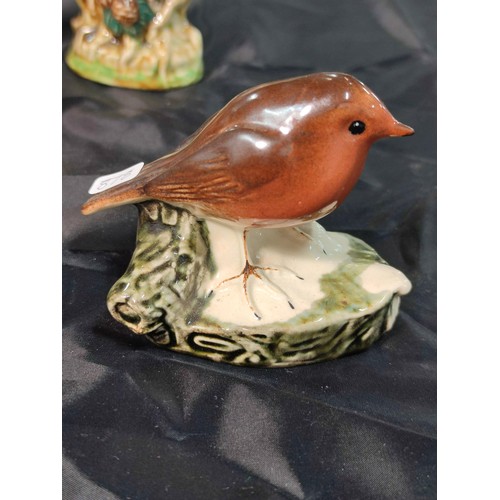 310 - A quantity of 8 bird figurines including a robin and an owl by Barmouth pottery, a Beswick bullfinch... 