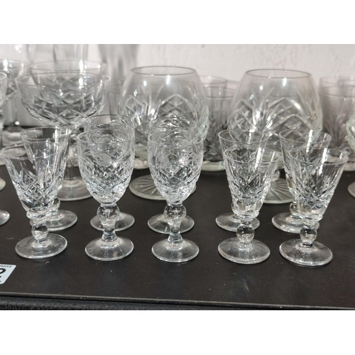 322 - A large quantity of glassware including many matching sets crystal cut etched glass sherry glasses, ... 