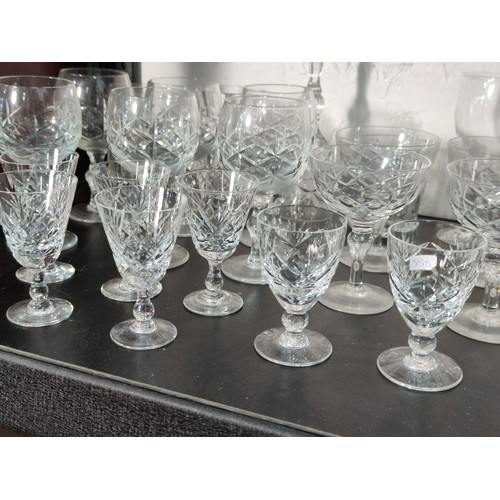 322 - A large quantity of glassware including many matching sets crystal cut etched glass sherry glasses, ... 