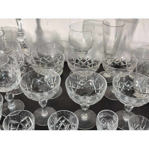 322 - A large quantity of glassware including many matching sets crystal cut etched glass sherry glasses, ... 