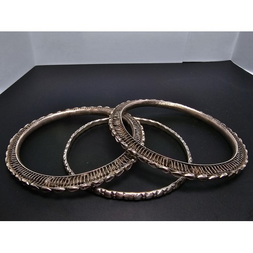 219 - A collection of 3 hand made silver bangles in the style of Kada Kangan with intricate designs to the... 