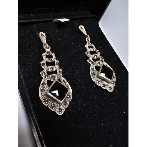 223 - A pair of matching 925 silver earrings inset with black onyx stones and decorated with CZ stones, ea... 