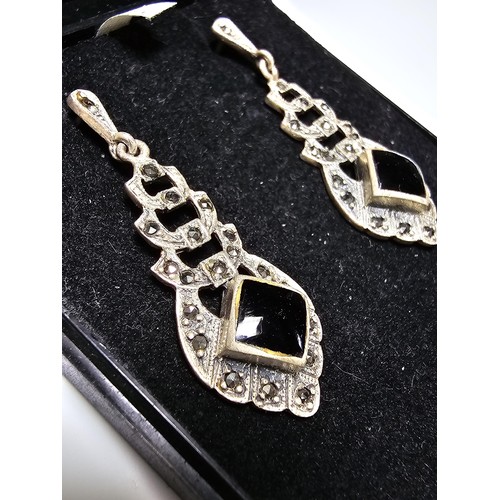 223 - A pair of matching 925 silver earrings inset with black onyx stones and decorated with CZ stones, ea... 