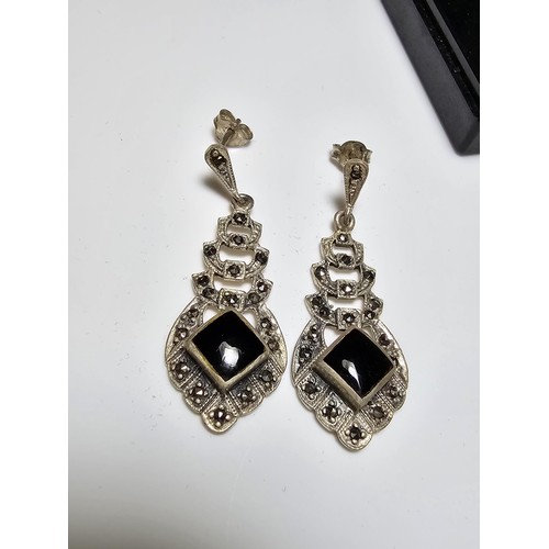 223 - A pair of matching 925 silver earrings inset with black onyx stones and decorated with CZ stones, ea... 