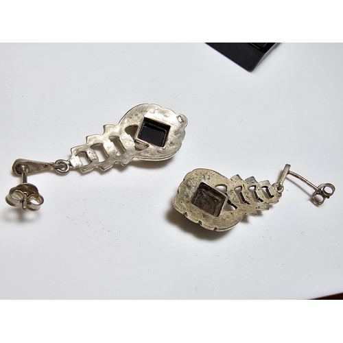 223 - A pair of matching 925 silver earrings inset with black onyx stones and decorated with CZ stones, ea... 