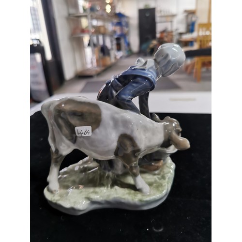 147 - A good quality Royal Copenhagen figurine of a lady feeding a cow along with a Danish ceramic figure ... 