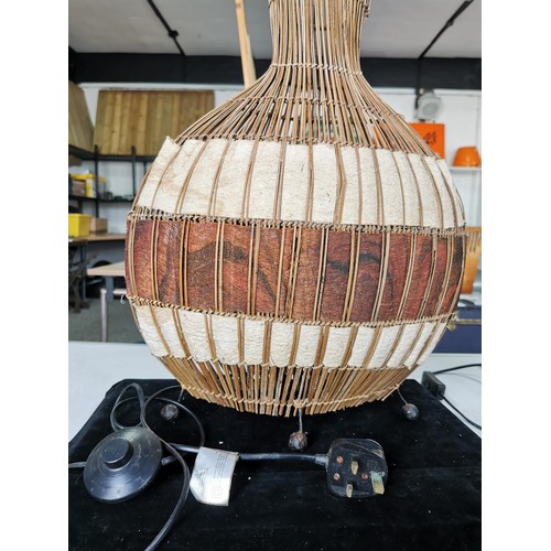 433 - A large tabletop lamp with a natural woven African fabric lamb along with a tall reed formed African... 