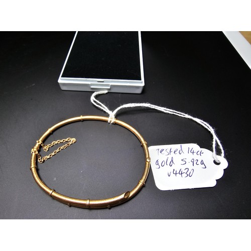 256 - 14ct Yellow Gold hinged Bangle in the form of bamboo complete with safety chain. Weight of 5.92 gram... 