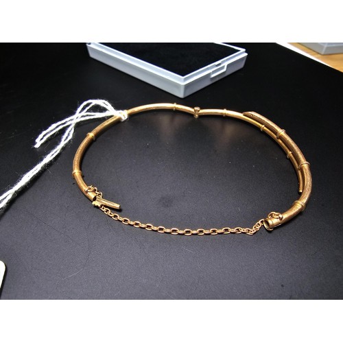 256 - 14ct Yellow Gold hinged Bangle in the form of bamboo complete with safety chain. Weight of 5.92 gram... 