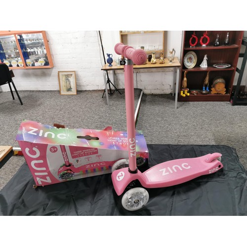 96 - A boxed zinc child's pink scooter with light up wheels. In good overall condition with adjustable ha... 