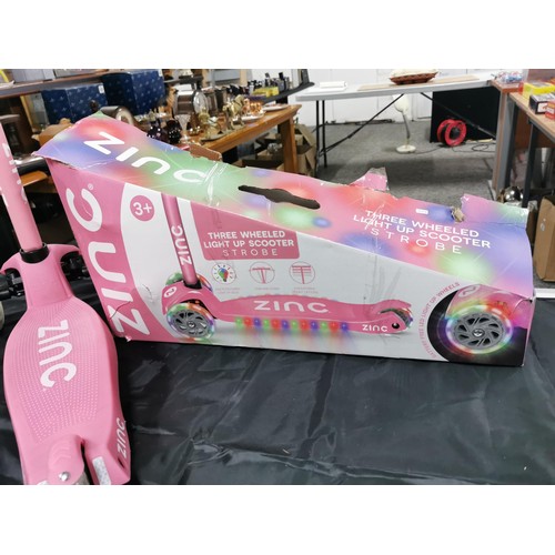 96 - A boxed zinc child's pink scooter with light up wheels. In good overall condition with adjustable ha... 