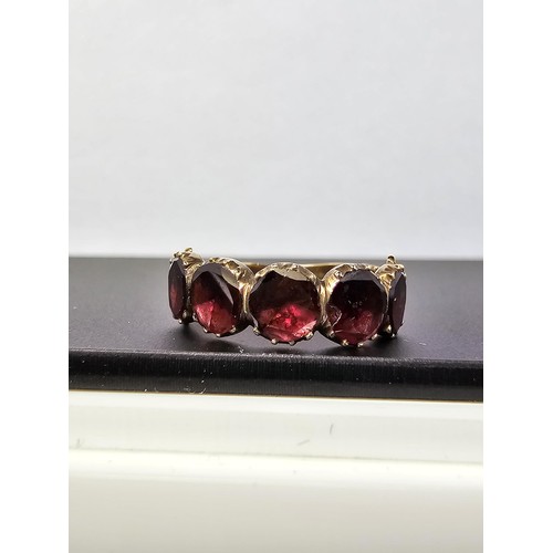 266 - 14ct Yellow Gold Ring inset with 5 Almandine Garnet stones which are faceted flat to the mount, the ... 