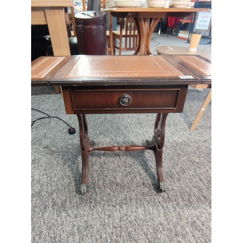 455 - A small leather top drop leaf occasional table with single draw and lyre style legs standing on lion... 