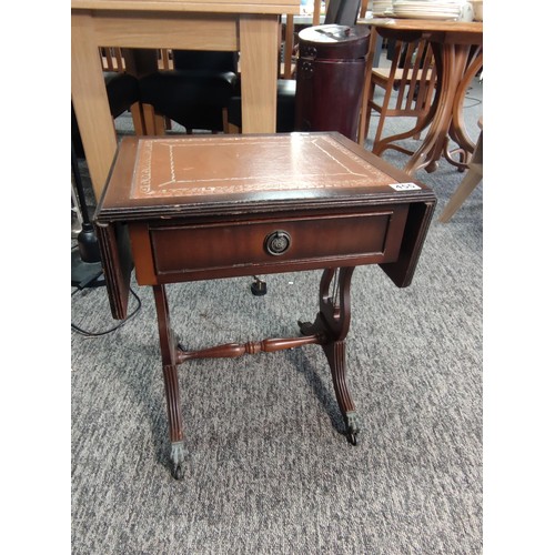 455 - A small leather top drop leaf occasional table with single draw and lyre style legs standing on lion... 