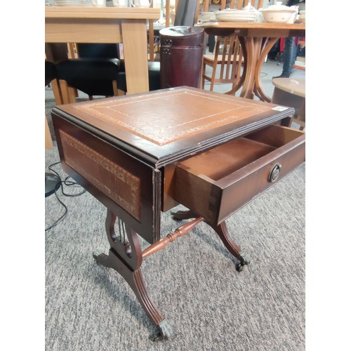 455 - A small leather top drop leaf occasional table with single draw and lyre style legs standing on lion... 