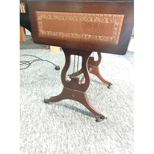 455 - A small leather top drop leaf occasional table with single draw and lyre style legs standing on lion... 