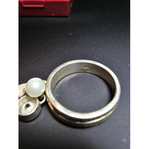 230 - 925 silver ring featuring 3x charms which includes a real pearl. in good condition boxed, size M.5