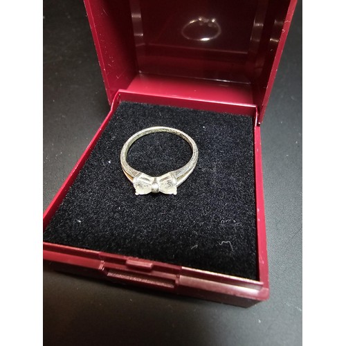 252 - 925 silver ring inset with cz crystal stones in the form of a bow, in good clean condition boxed siz... 