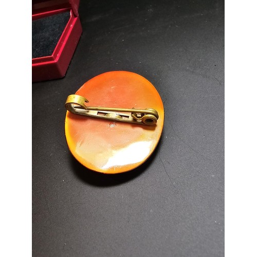 274 - Lovely vintage carved cameo brooch in faux amber, in good condition boxed.