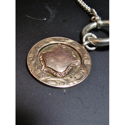 313 - A Hallmarked Silver pocket watch fob with a Solid Gold blank shield cartouche to the front set on a ... 