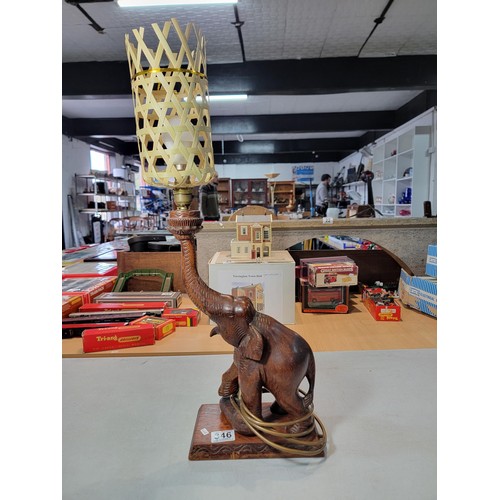 346 - A beautifully carved solid wood Elephant formed lamp with wicker shade. A good statement piece prese... 