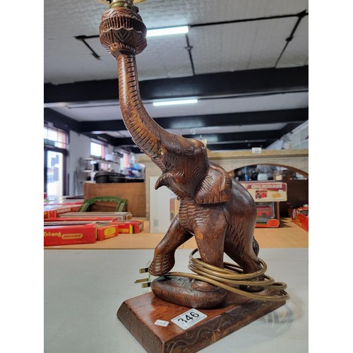 346 - A beautifully carved solid wood Elephant formed lamp with wicker shade. A good statement piece prese... 