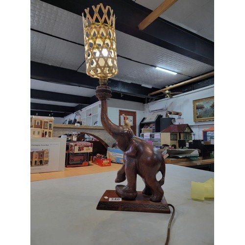 346 - A beautifully carved solid wood Elephant formed lamp with wicker shade. A good statement piece prese... 