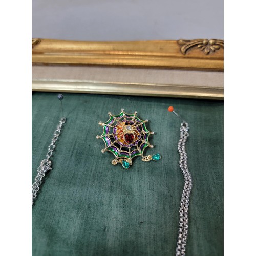 357 - A suite of 10x ornate Brooches and Necklaces fitted on a gilt framed display board (included)