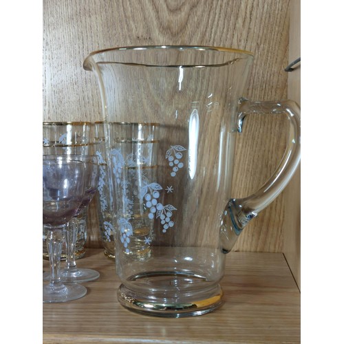 386 - A quantity of vintage glassware to include 2 gold rimmed and etched jugs with 12 matching glasses al... 