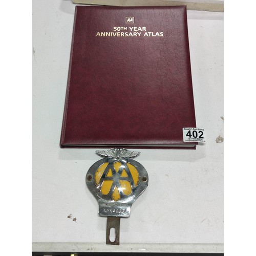 402 - An early vintage AA car badge along with an AA 50th year anniversary atlas, complete with original m... 