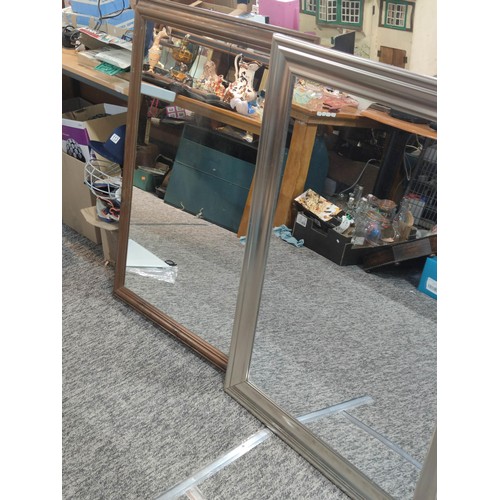 406 - 2 framed large wall mirrors, 1 with a silver frame the other in natural wood. Largest measures 1m an... 