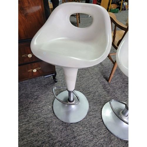 573 - 2 swivel bar stools in cream. Gas adjustable in height