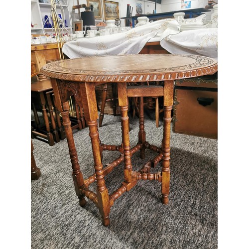 552 - A drop leaf decoratively carving to top circular  lamp or window table.
65cm diameter