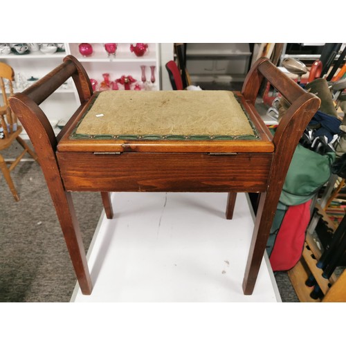 555 - Lift up lid piano stool of oak with padded seat top