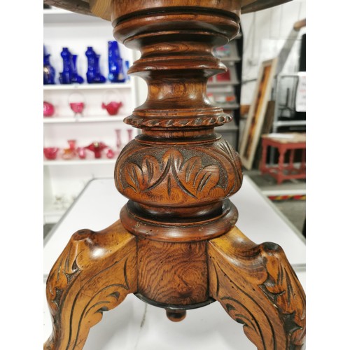 557 - Wooden Piano stool with intricate carvings to tripod legs red seat pad in good order