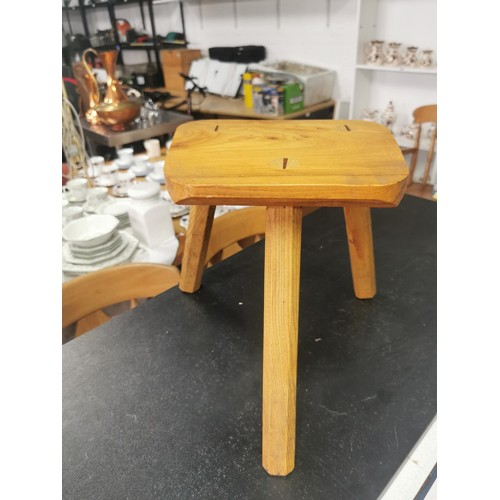 558 - A wooden milking stool and a wooden plaque.