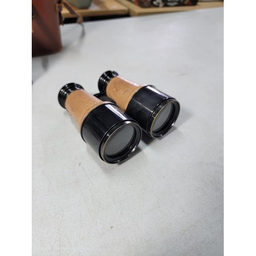 76 - 2x binoculars to include a vintage leather wrapped pair of military spotting binoculars in a good le... 