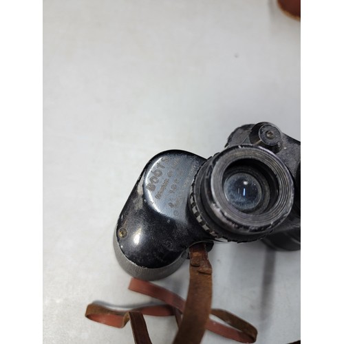 76 - 2x binoculars to include a vintage leather wrapped pair of military spotting binoculars in a good le... 