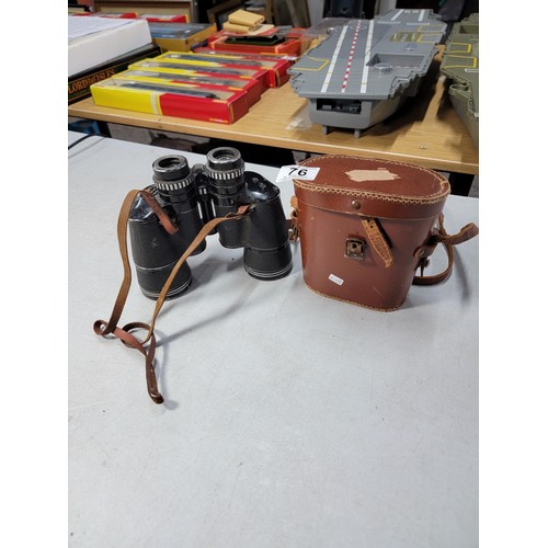 76 - 2x binoculars to include a vintage leather wrapped pair of military spotting binoculars in a good le... 