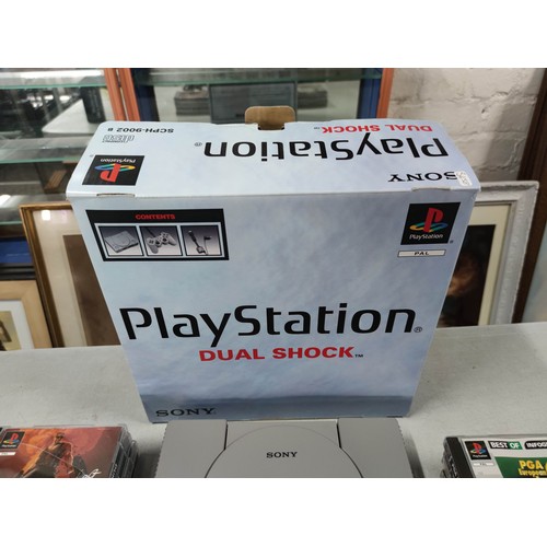 16 - A Sony Playstation dual shock edition games console along with a good selection of games. In great c... 