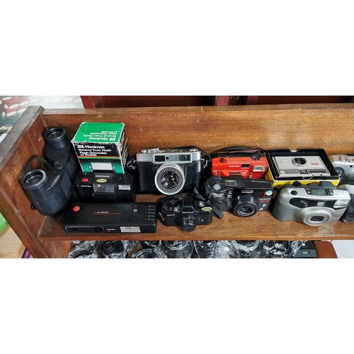 57 - A large quantity of various cameras to include SLR and digital cameras and a pair of binoculars. The... 