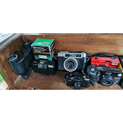 57 - A large quantity of various cameras to include SLR and digital cameras and a pair of binoculars. The... 