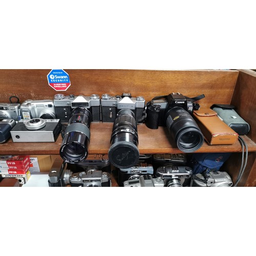 57 - A large quantity of various cameras to include SLR and digital cameras and a pair of binoculars. The... 