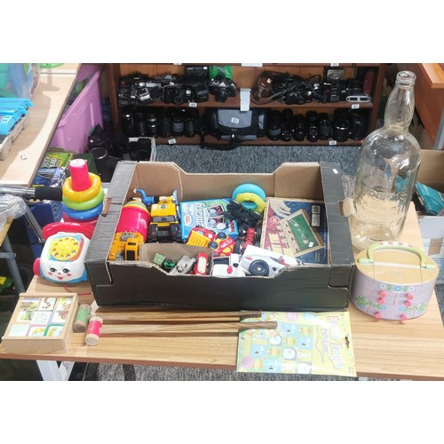 71 - A box full of various children's toys along with an large empty Bells scotch whisky 5l bottle. Inclu... 