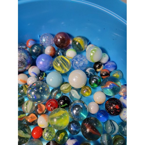 45 - A Cadbury Roses tub containing a quantity of various sized marbles inc large iridescent marbles, sol... 