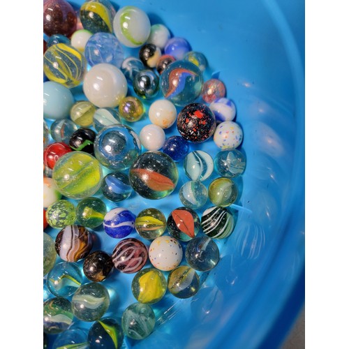 45 - A Cadbury Roses tub containing a quantity of various sized marbles inc large iridescent marbles, sol... 