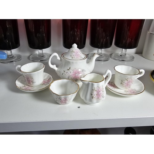 101 - A shelf of collectable items to include a set of 6 sherry ruby glasses, Royal commemorative mugs, a ... 